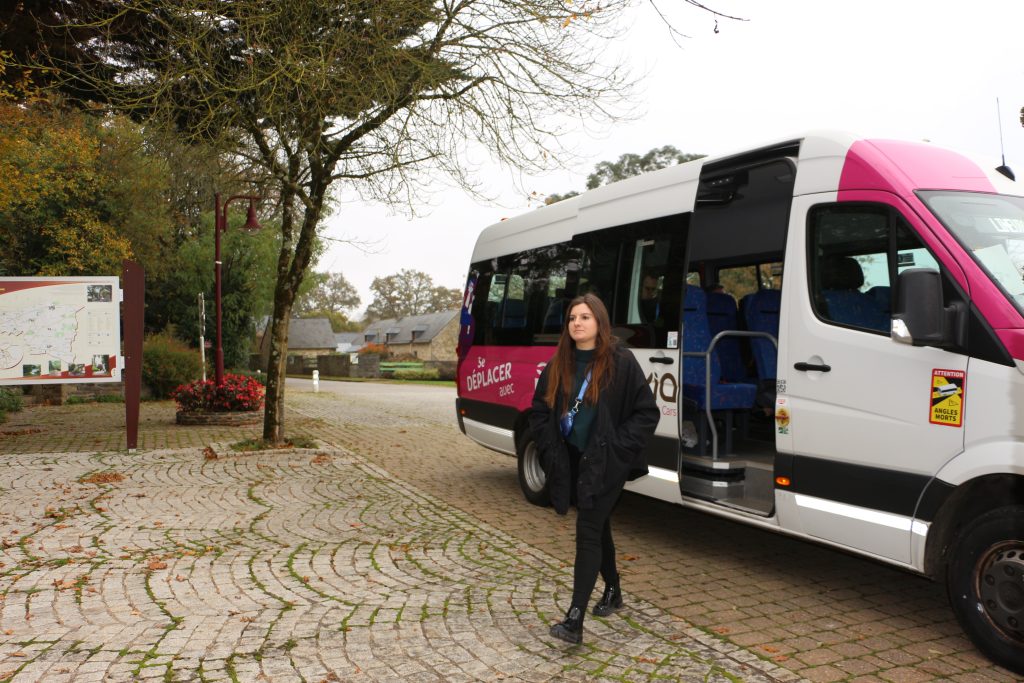 Elise Joly devant un minibus de la ligne de bus de l’intercommunalité